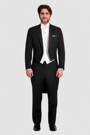 Man in a black tuxedo with a white waistcoat and bow tie, tails visible, standing against a light background.